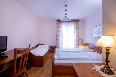 a room with two beds and a table and a desk at Tourist farm Pri Andrejevih in Narin