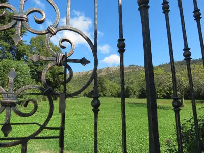 an iron gate with a field of grass at Tourist farm Pri Andrejevih in Narin
