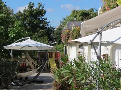 a playground with an umbrella and a slide at Tourist farm Pri Andrejevih in Narin