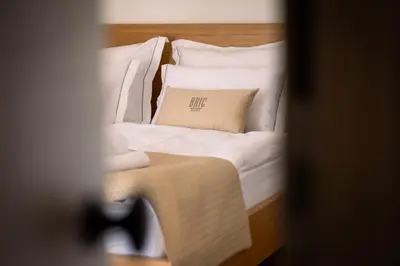 a bed with white sheets and a pillow on it at BRIC Wine & Relax in Vogrsko