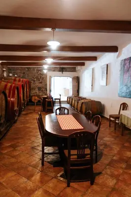 a room with a table and chairs and a bunch of wine barrels at BRIC Wine & Relax in Vogrsko