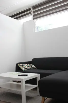 a living room with a black couch and a table at apartma pika in Šempeter pri Gorici
