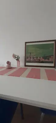 a white table with a painting on the wall at apartma pika in Šempeter pri Gorici