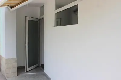 a door in a white wall with a window at apartma pika in Šempeter pri Gorici