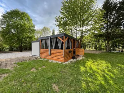 a small cabin in a field with trees at Mobile home T&N - Camp Velenje in Velenje