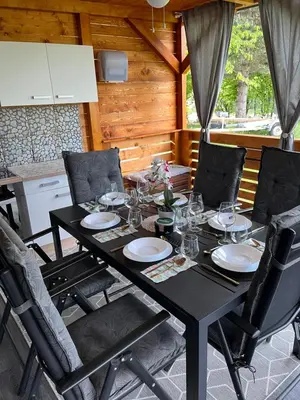 a black table with chairs and plates and glasses on it at Mobile home T&N - Camp Velenje in Velenje
