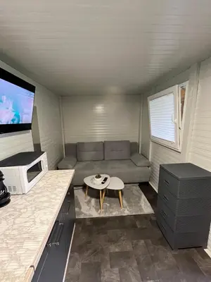 a small living room with a couch and a table at Mobile home T&N - Camp Velenje in Velenje
