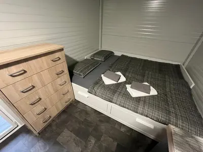 a small room with two beds and a dresser at Mobile home T&N - Camp Velenje in Velenje