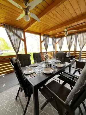 a dining room table with chairs and a ceiling fan at Mobile home T&N - Camp Velenje in Velenje