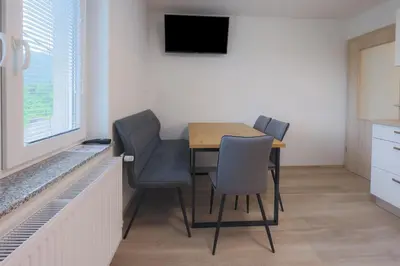 a dining room with a table and chairs and a television at Apartment Erika in Bled