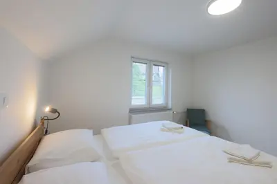two white beds in a room with a window at Apartment Erika in Bled