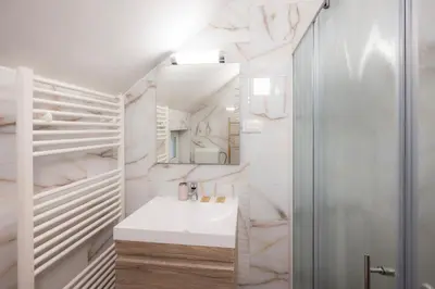 a white bathroom with a sink and a shower at Apartment Erika in Bled