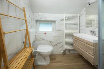 a bathroom with a toilet and a sink and a window at Apartment Erika in Bled