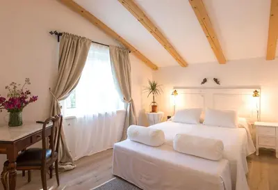 a bedroom with a white bed with a desk and a window at Villa Loren in Avber