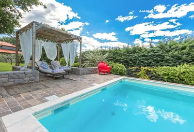 a swimming pool with a gazebo next to at Villa Loren in Avber