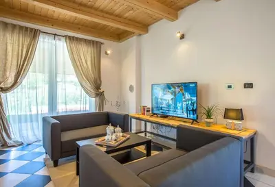 a living room with a couch and a tv at Villa Loren in Avber
