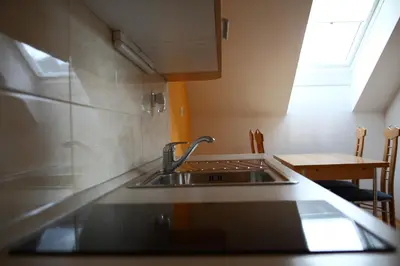 a kitchen with a sink and a table with a window at Apartments at Gostilna Martin in Trbovlje