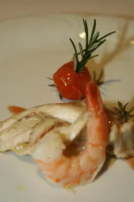a plate of food with shrimp and a tomato at Apartments at Gostilna Martin in Trbovlje