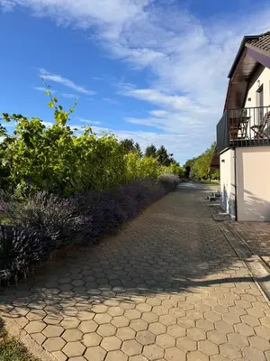 a cobblestone path next to a building with a balcony at Holiday home Ana in Fokovci