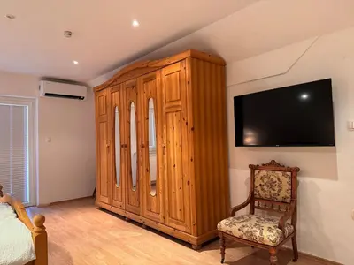 a bedroom with a wooden cabinet and a tv at Holiday home Ana in Fokovci