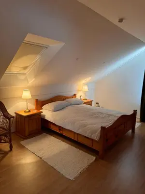 a bedroom with a large wooden bed in a attic at Holiday home Ana in Fokovci