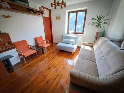 a living room with a couch and a chair at Hikers Hut Hišar in Podbrdo