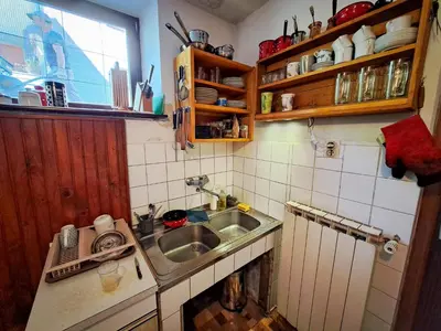 a small kitchen with a sink and a window at Hikers Hut Hišar in Podbrdo