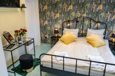 a bedroom with a bed with yellow pillows and a wallpaper at Diamond dream in Ptuj