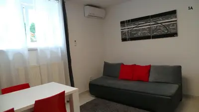 a living room with a couch and red pillows at Boutique Apartments in Ljubljana