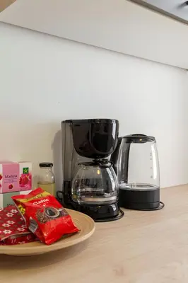 a coffee maker and a bag of chips on a counter at Cosy and Bright Apartment in Ljubljana