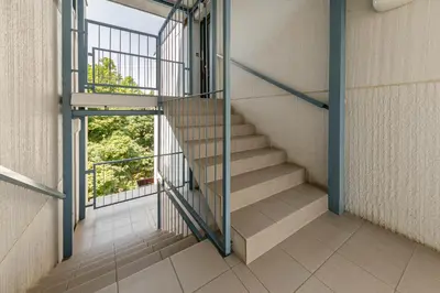 a staircase in a building with a glass railing at Cosy and Bright Apartment in Ljubljana