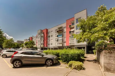 a car parked in a parking lot in front of a building at Cosy and Bright Apartment in Ljubljana