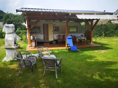 a group of chairs and tables in a yard at Počitniška prikolica Zeleni raj in Podnart