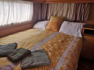 a bed with pillows on it in a room at Počitniška prikolica Zeleni raj in Podnart