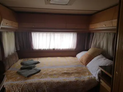a small bedroom with a bed in a caravan at Počitniška prikolica Zeleni raj in Podnart