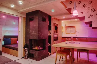 a living room with a fireplace and a table with wine glasses at Luxury Chalet & Sauna Kati - Velika Planina - I Feel Alps in Stahovica