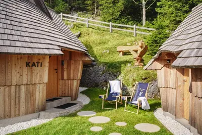 a backyard with two chairs and a table in the yard at Luxury Chalet & Sauna Kati - Velika Planina - I Feel Alps in Stahovica