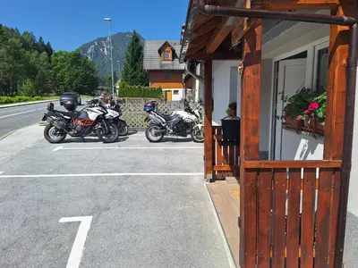two motorcycles parked in a parking lot next to a building at Apartma Bogi Kranjska Gora in Kranjska Gora