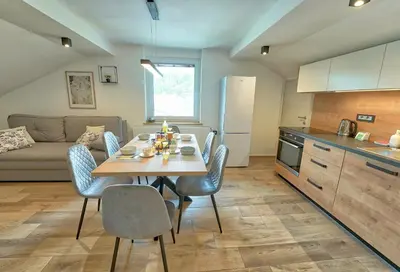 a kitchen and dining room with a table and chairs at Apartments Lipa Plac in Postojna