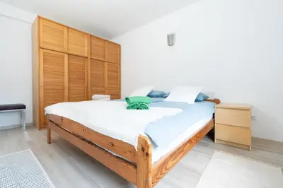 a bedroom with a large bed with a wooden headboard at Apartments BUMM in Ljubljana