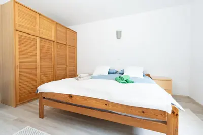 a bedroom with a large bed with a wooden headboard at Apartments BUMM in Ljubljana