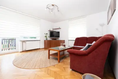a living room with a red chair and a coffee table at Apartments BUMM in Ljubljana