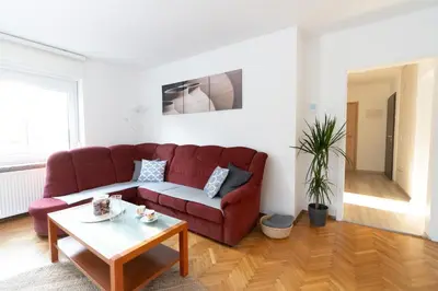 a living room with a red couch and a table at Apartments BUMM in Ljubljana
