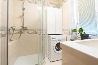 a bathroom with a washing machine and a washer at Apartments BUMM in Ljubljana