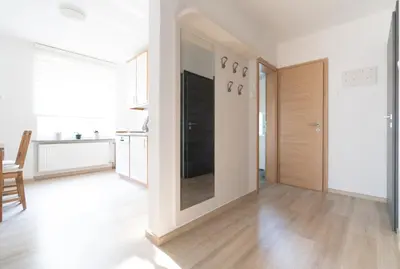 a living room with white walls and a wooden floor at Apartments BUMM in Ljubljana
