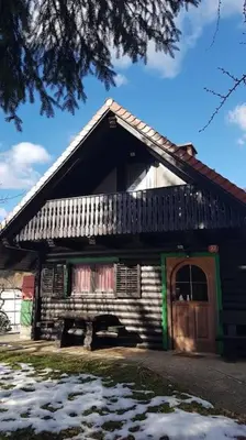 a house with a black roof and a wooden door at Chalet Kujavnk in Kranj