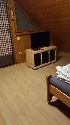 a room with a tv and a bed in a house at Chalet Kujavnk in Kranj