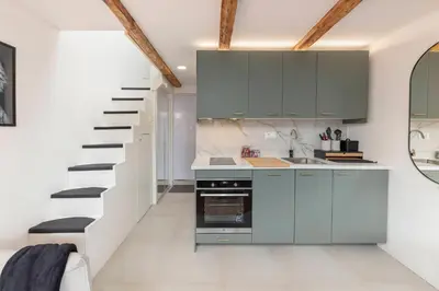 a kitchen with blue cabinets and a staircase at Studio Nensi in Ljubljana