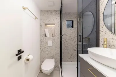 a white bathroom with a toilet and a sink at Studio Nensi in Ljubljana