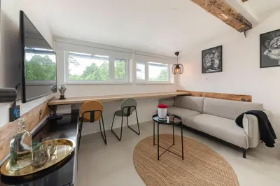 a living room with a couch and a table and chairs at Studio Nensi in Ljubljana
